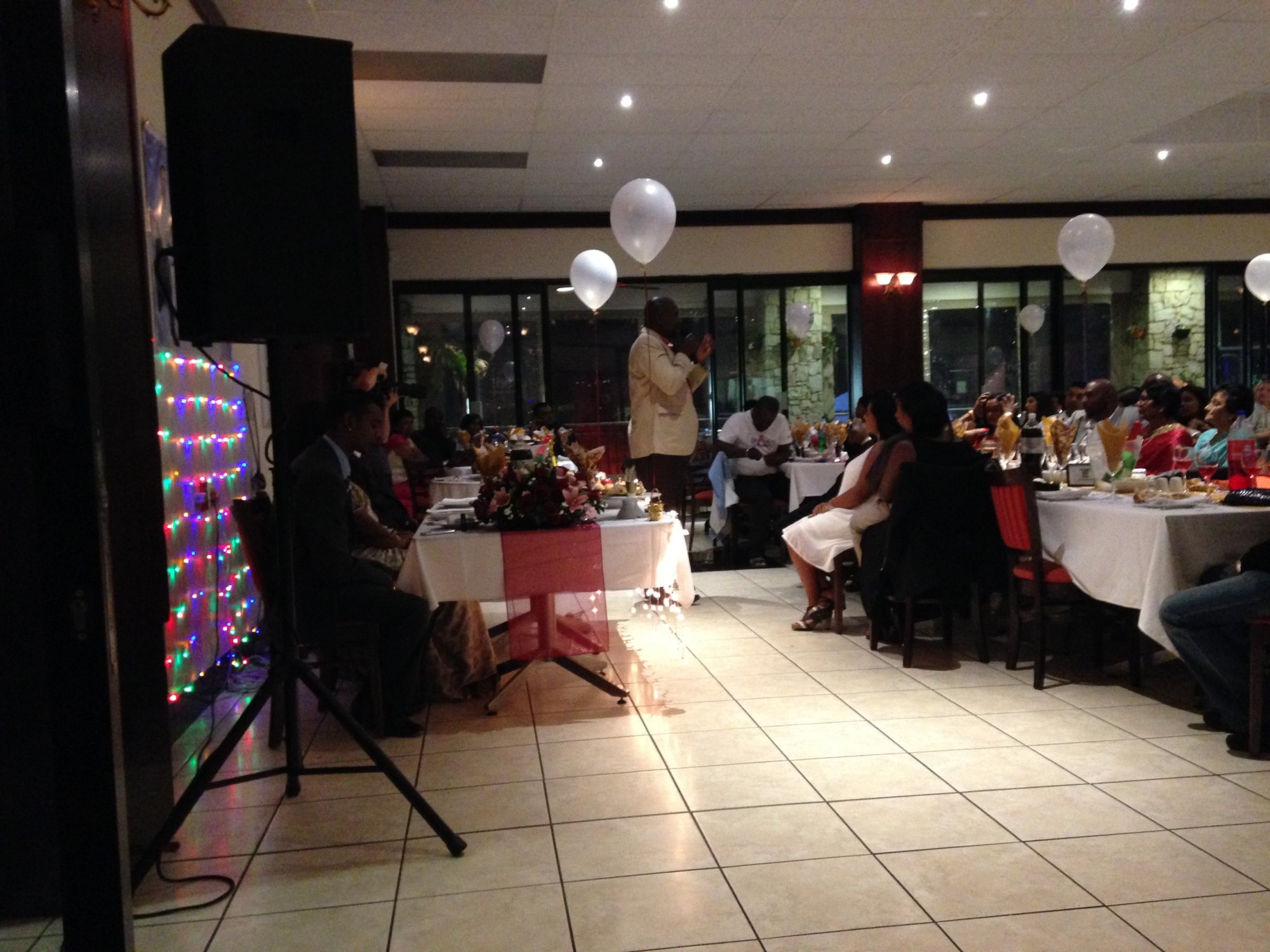 Event setup with decorated tables and PA system in a venue.