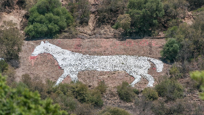 A large white horse figure painted on a rocky surface.