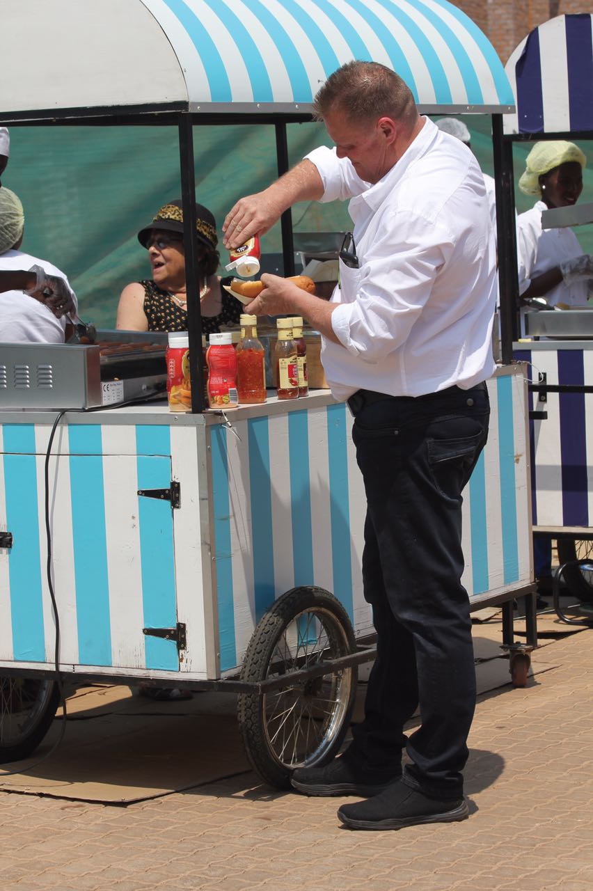 Person serving snacks from a striped food cart