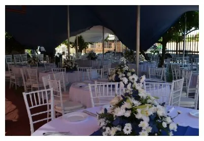 Outdoor event setup with tables and floral centerpieces