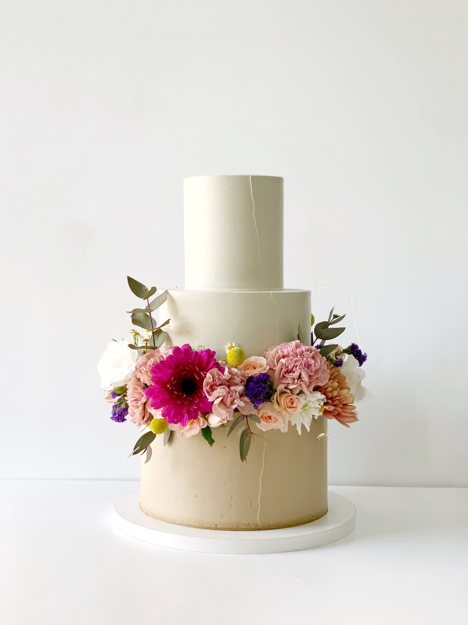 Beige tiered wedding cake with floral decorations
