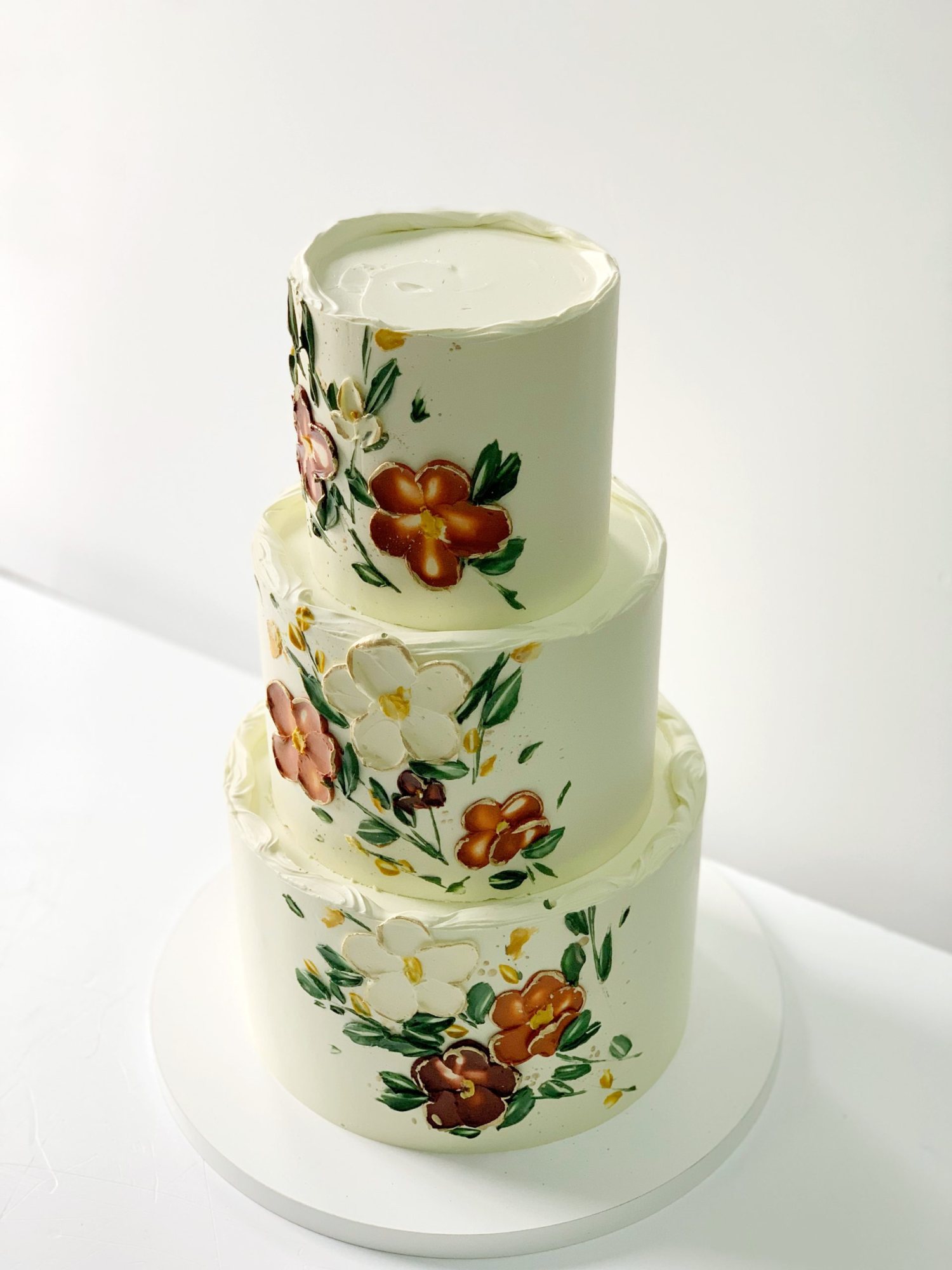 Three-tier cake with hand-painted floral designs