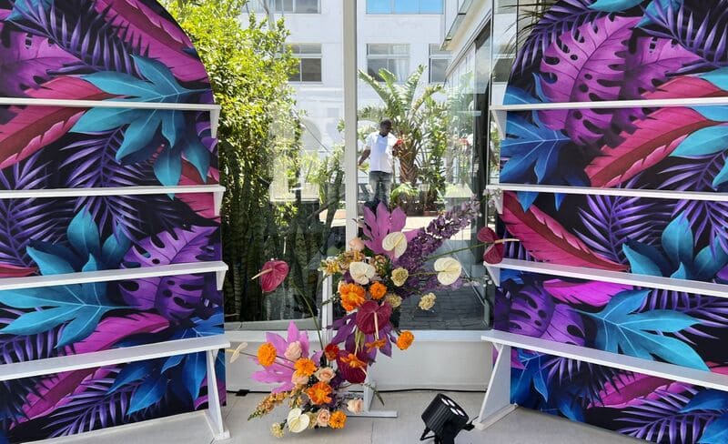 Tropical backdrop with floral arrangement for event decor.