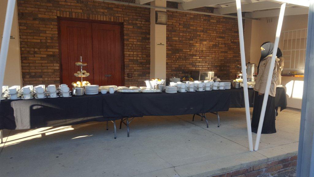 Catering setup with plates and serving dishes on a table.