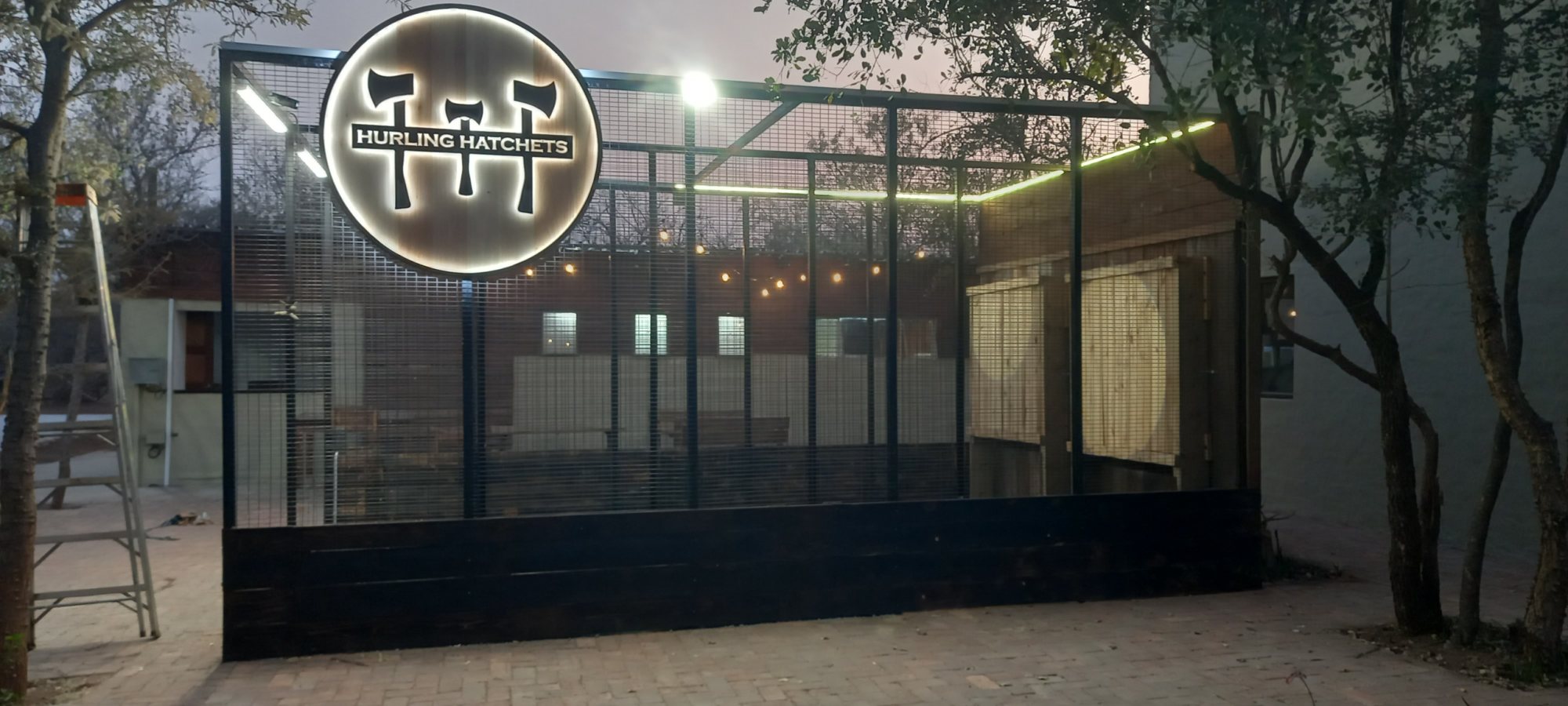 Outdoor axe throwing area with brand logo
