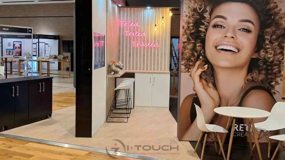 A vibrant exhibition stand with bright neon signage and a large model image.