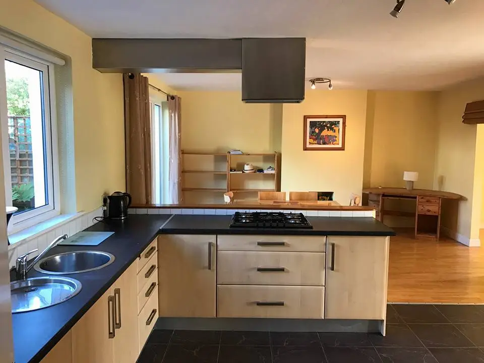 Bright modern kitchen with wood cabinets and a gas stove.