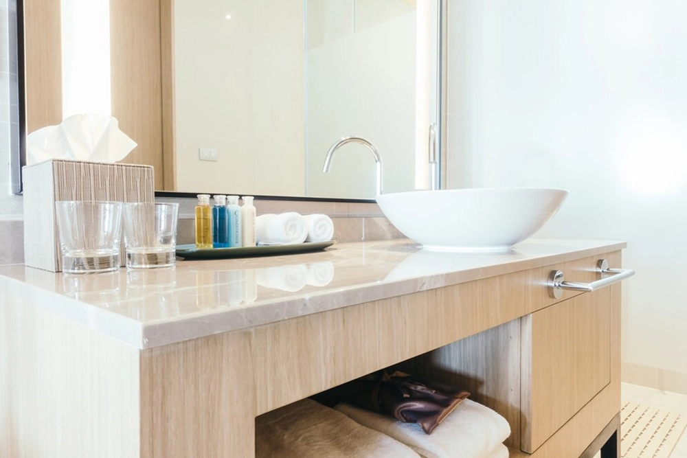Modern bathroom vanity with white basin and toiletries