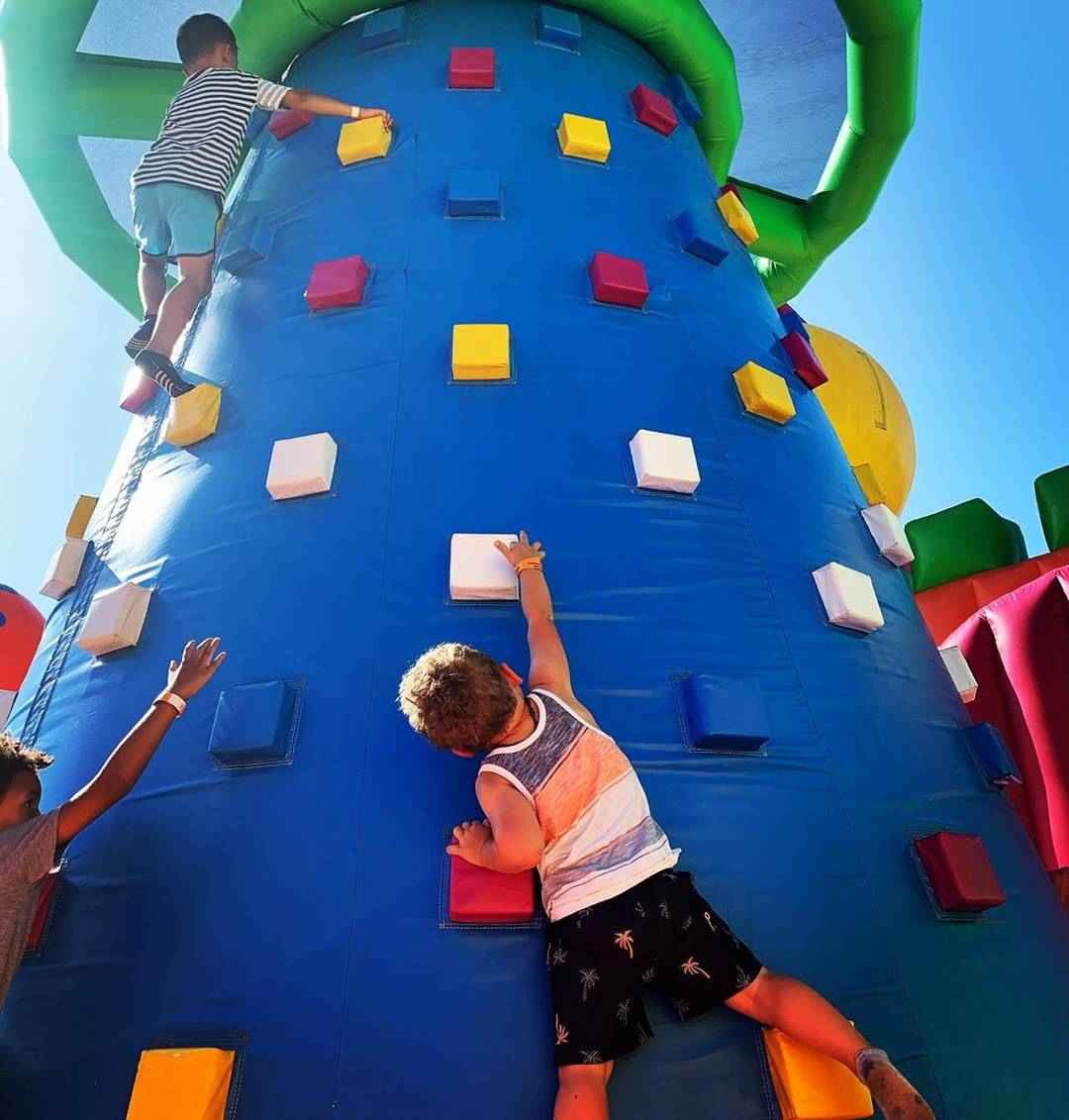 Children climbing a colorful inflatable tower
