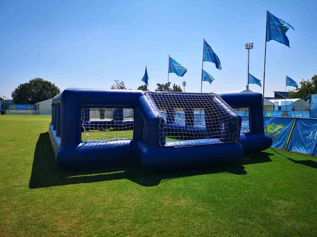 Blue inflatable soccer game on a grassy field