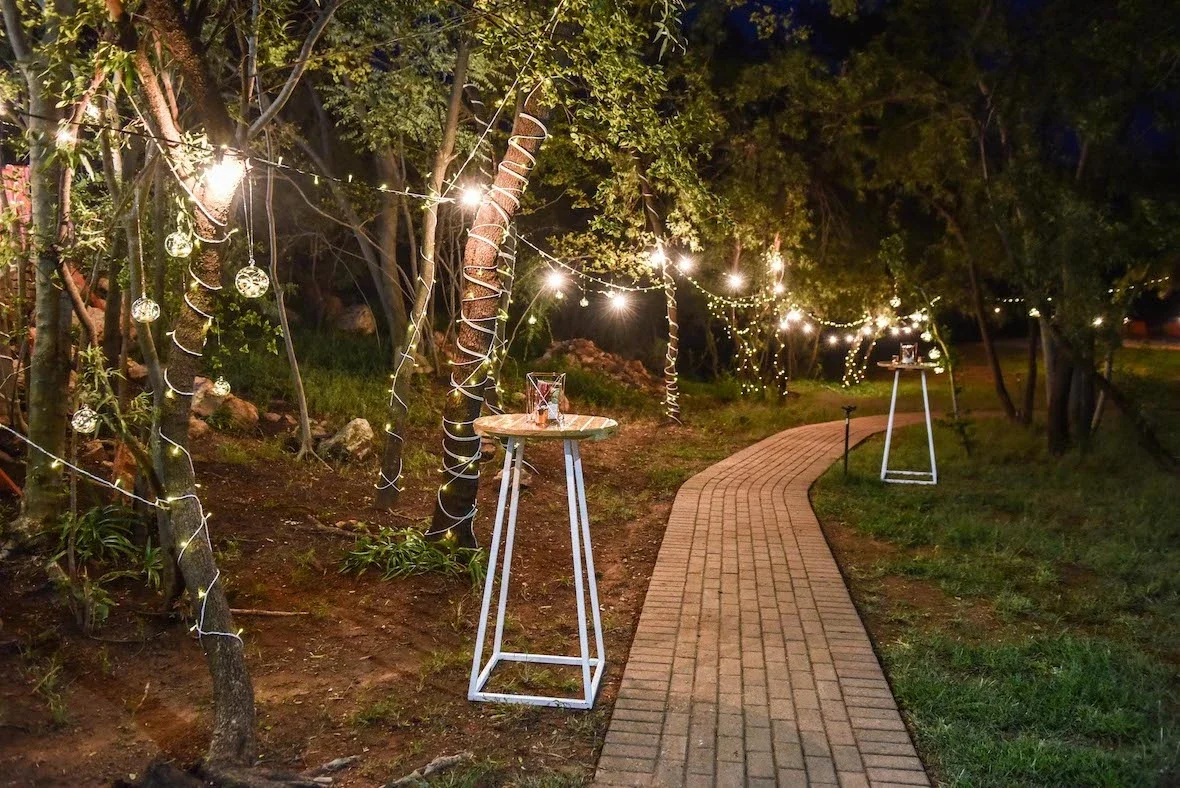 Pathway lined with fairy lights and standing tables
