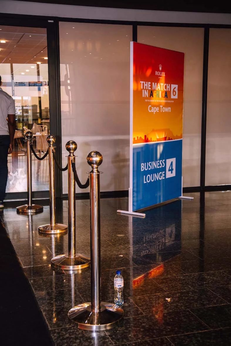 Entrance setup with stanchions and signage for an event