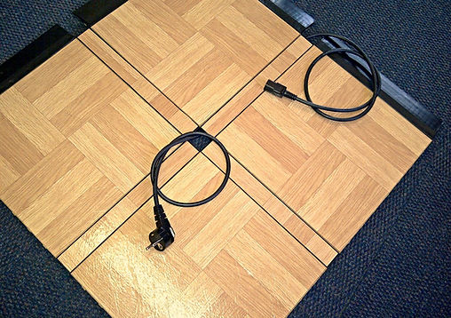 Close-up of modular flooring tiles with electrical cables