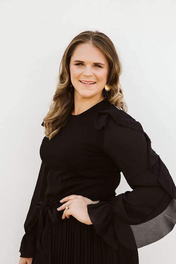 Woman in black attire smiling confidently
