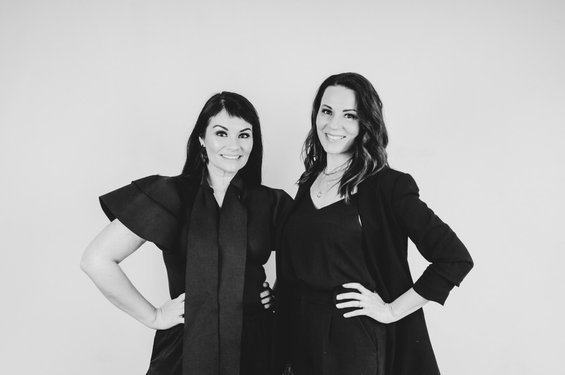 Two smiling wedding planners posing for a photo