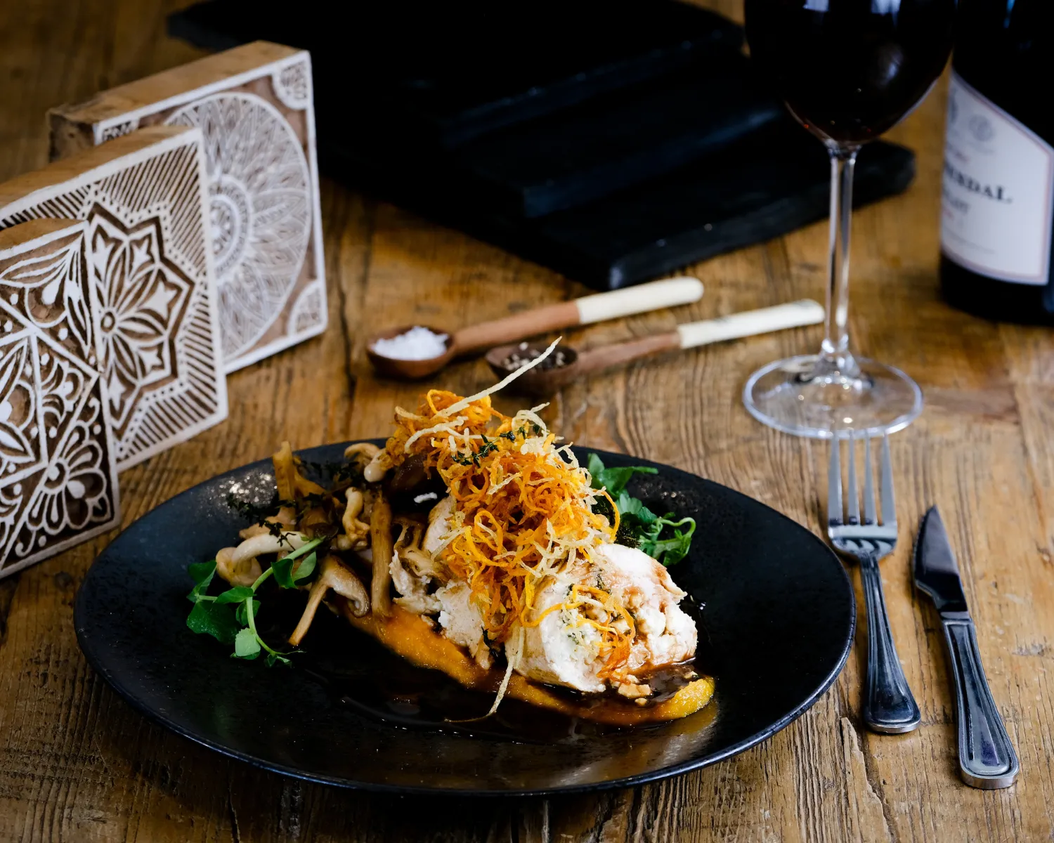 Gourmet chicken dish with greens and crispy onions