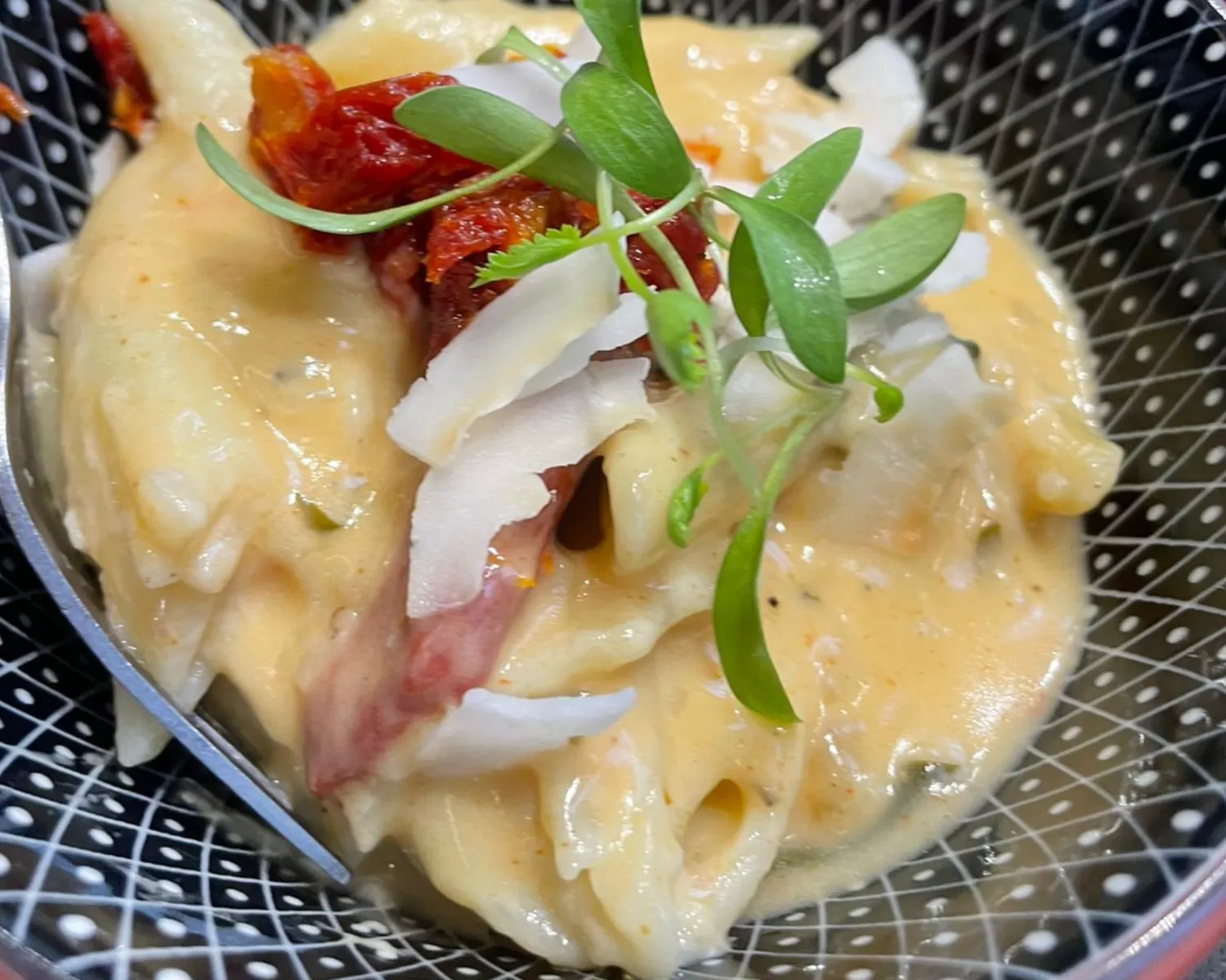 Creamy pasta with toppings in a decorative bowl.
