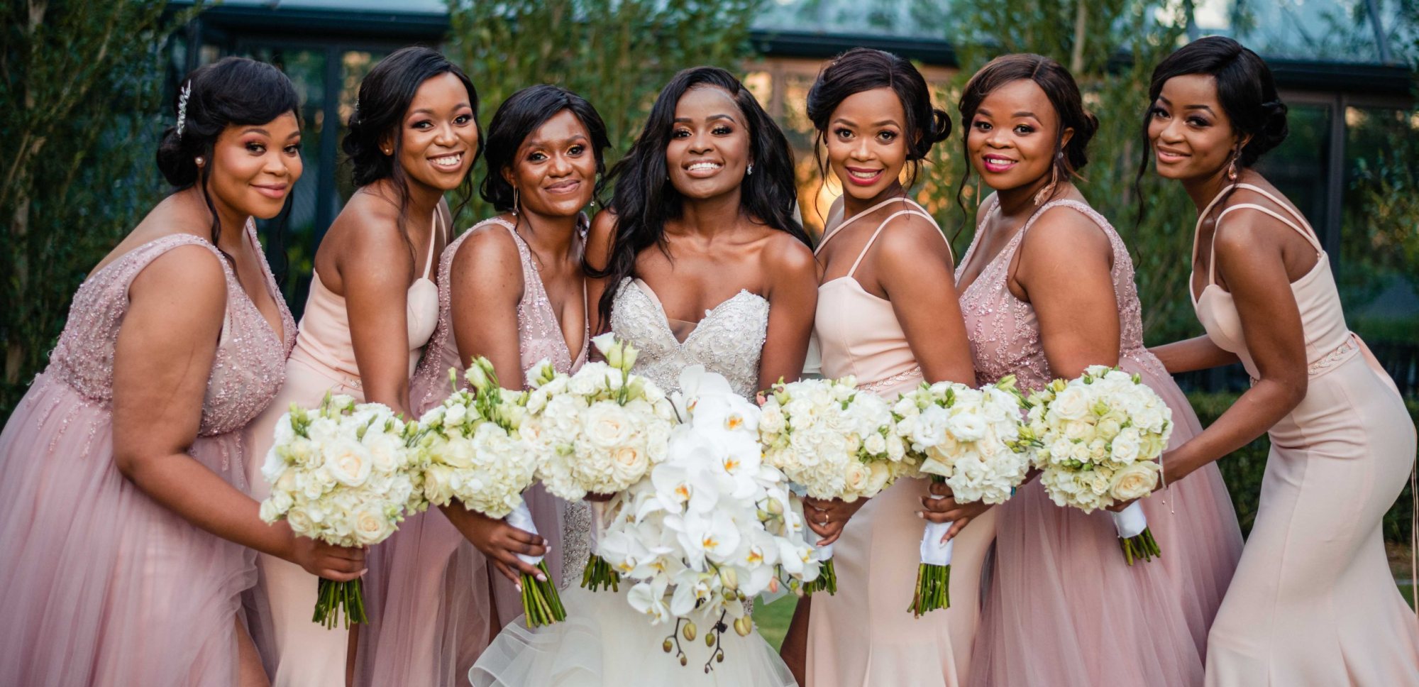 Bridal party poses with the bride holding bouquets