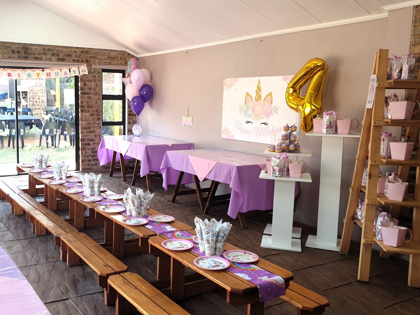Decorated tables for a child's birthday party with purple and pink theme.