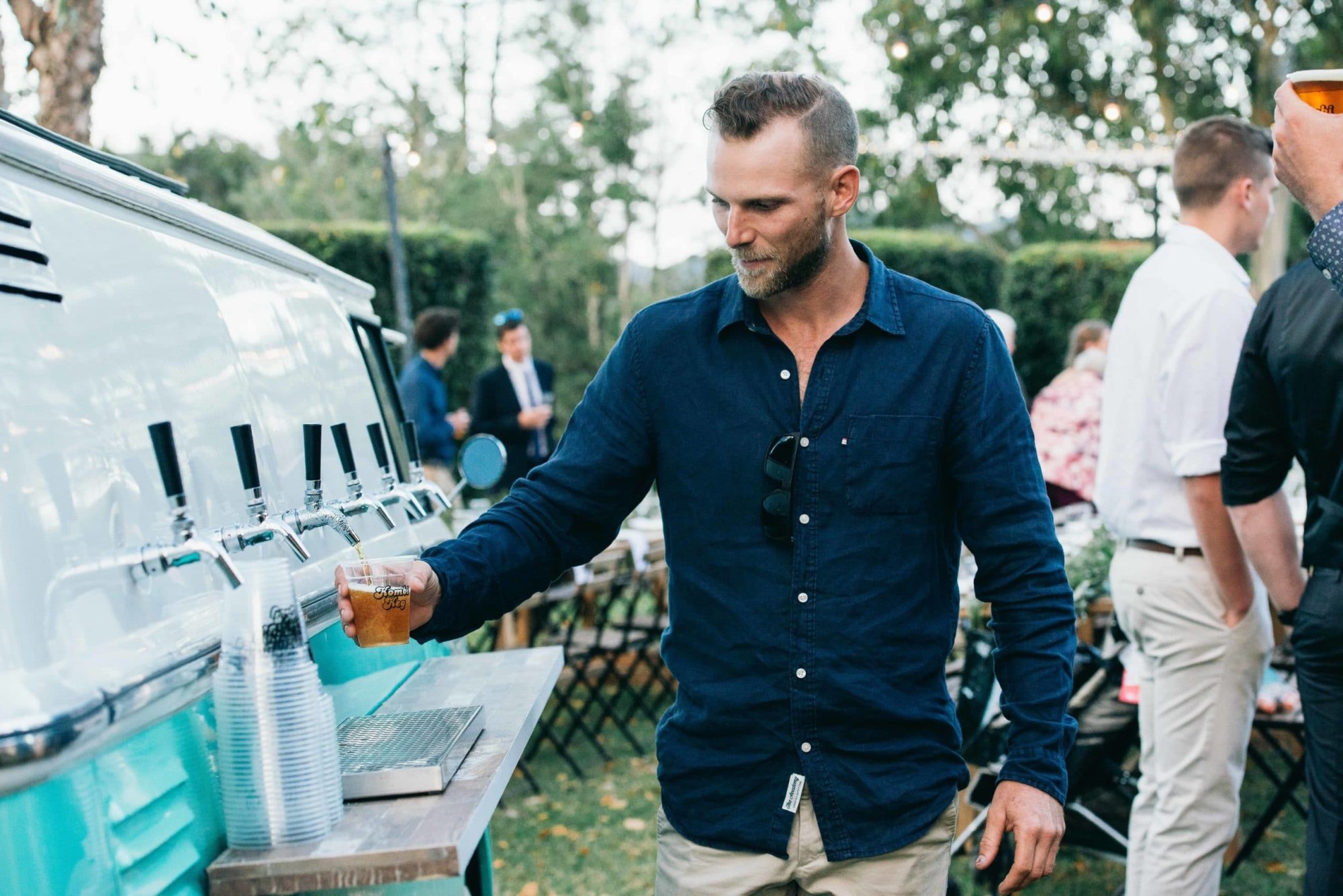 Man pouring a drink from the Kombi Keg mobile bar.