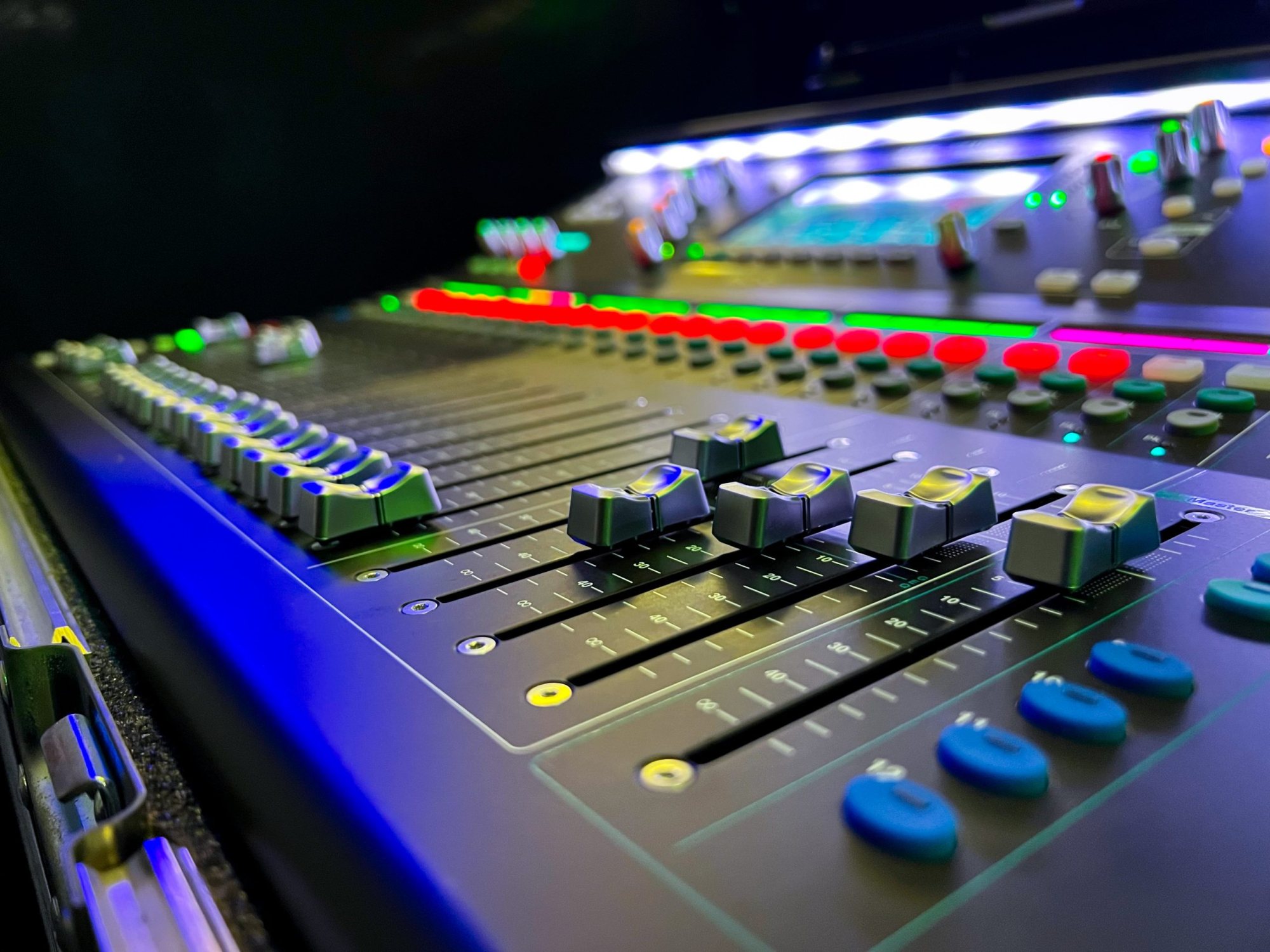 Close-up of a digital mixing console with controls