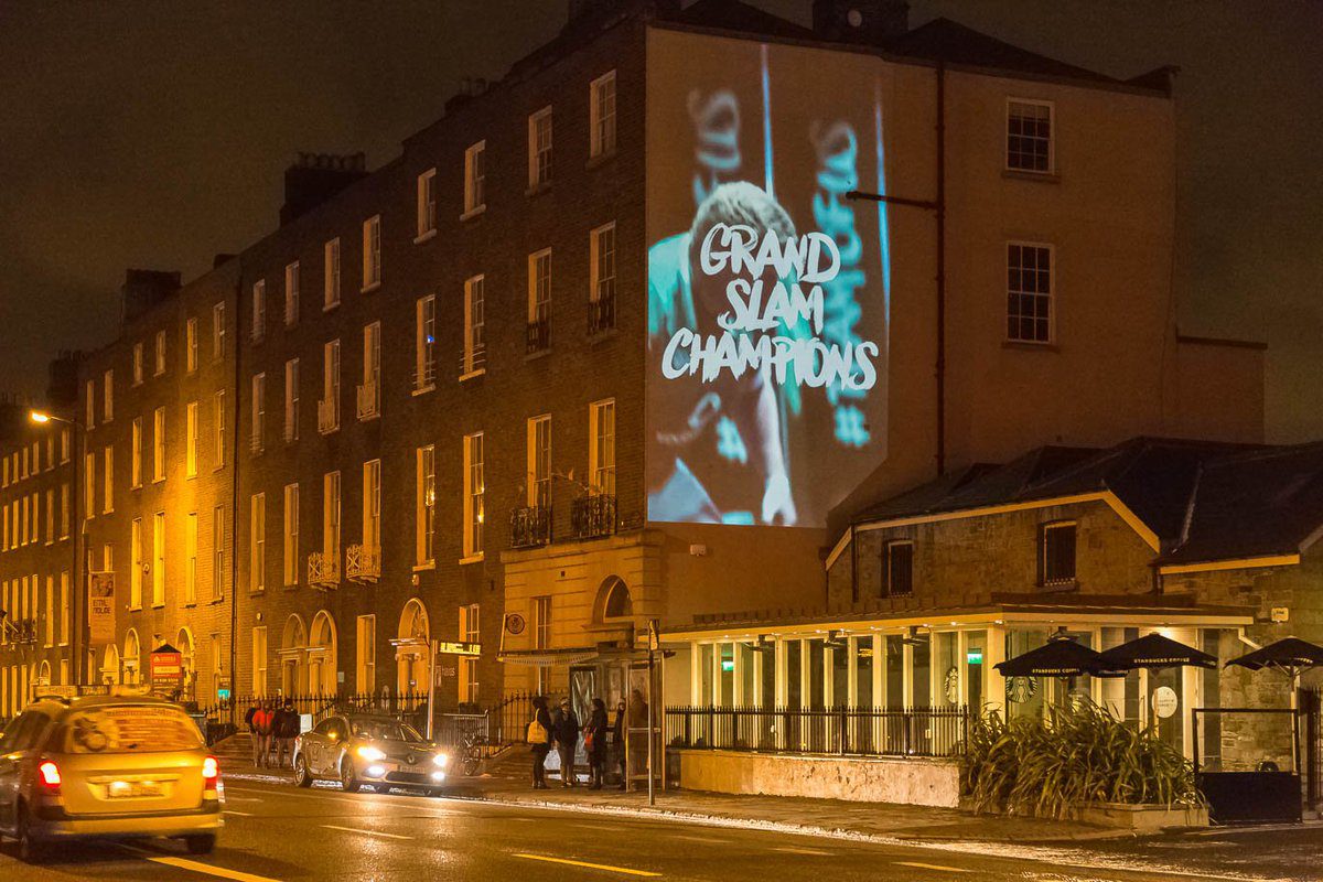 Projection of text on a building highlighting Grand Slam Champions