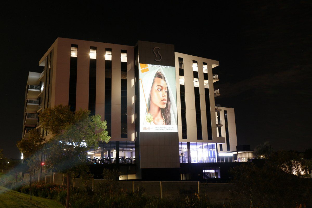 Building with a large projection of a woman's face at night