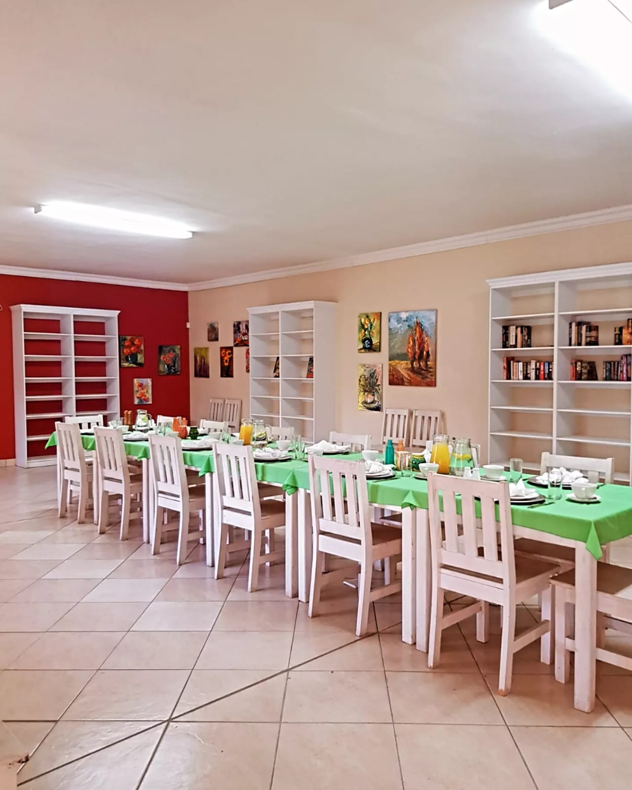 Dining room setup with white chairs and green tablecloths