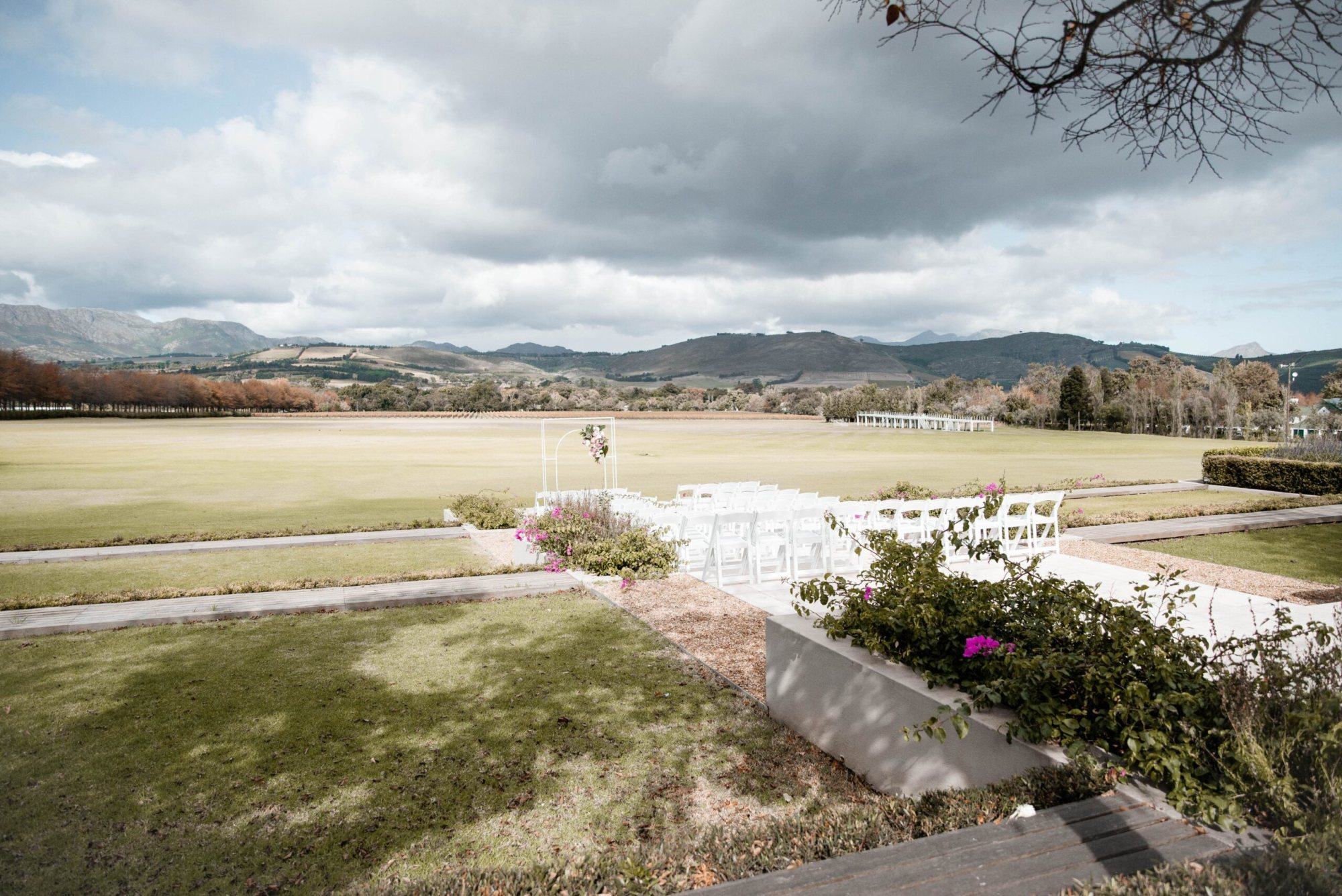 Ceremony setup with white chairs and mountains in background