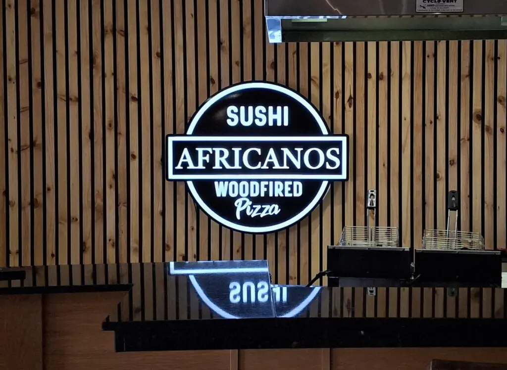 Africanos Woodfired Pizza logo on wooden wall