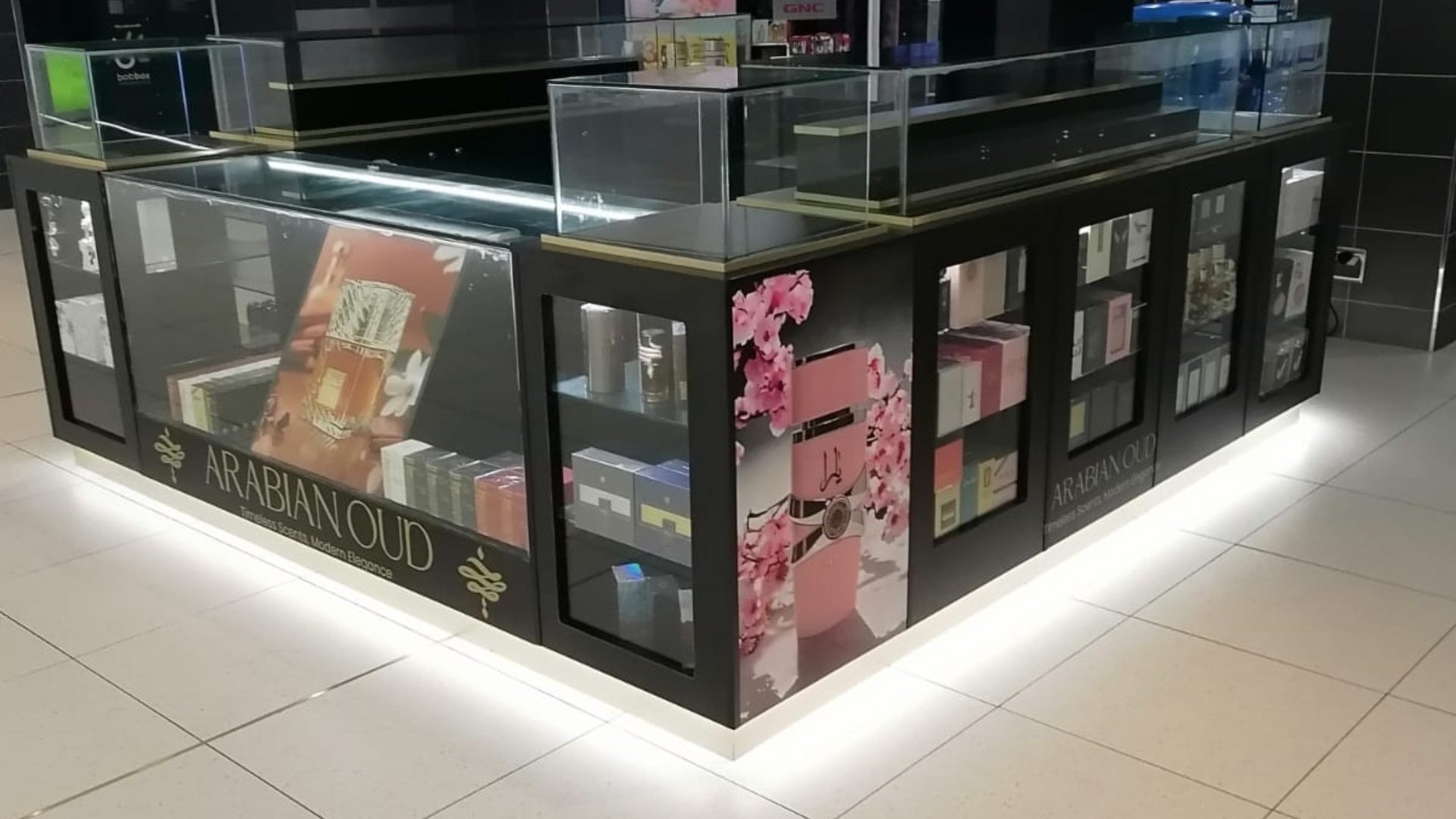 Retail display counter featuring various product boxes and floral decorations.