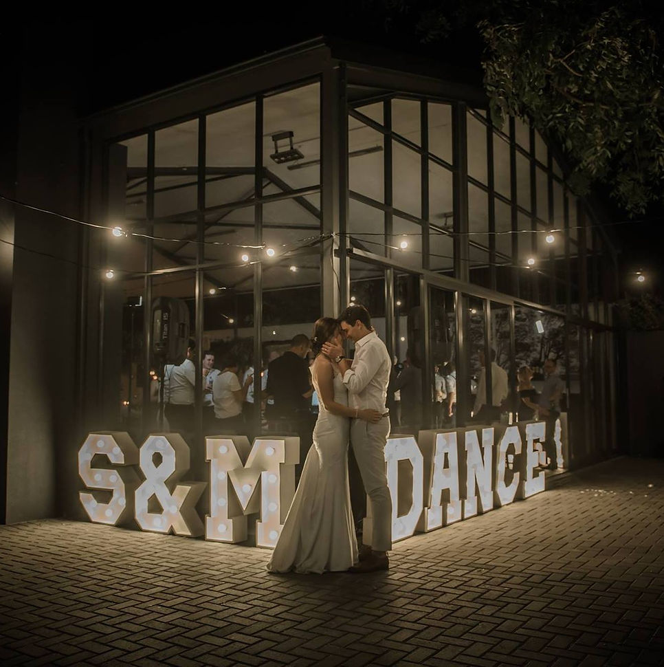Life-size illuminated marquee letters spelling S & M DANCE