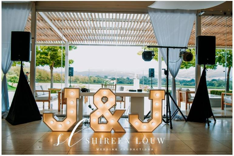 Illuminated marquee letters 'J & J' displayed at an event.