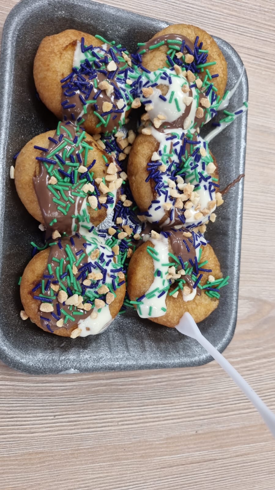 Plate of mini doughnuts with chocolate and sprinkling toppings