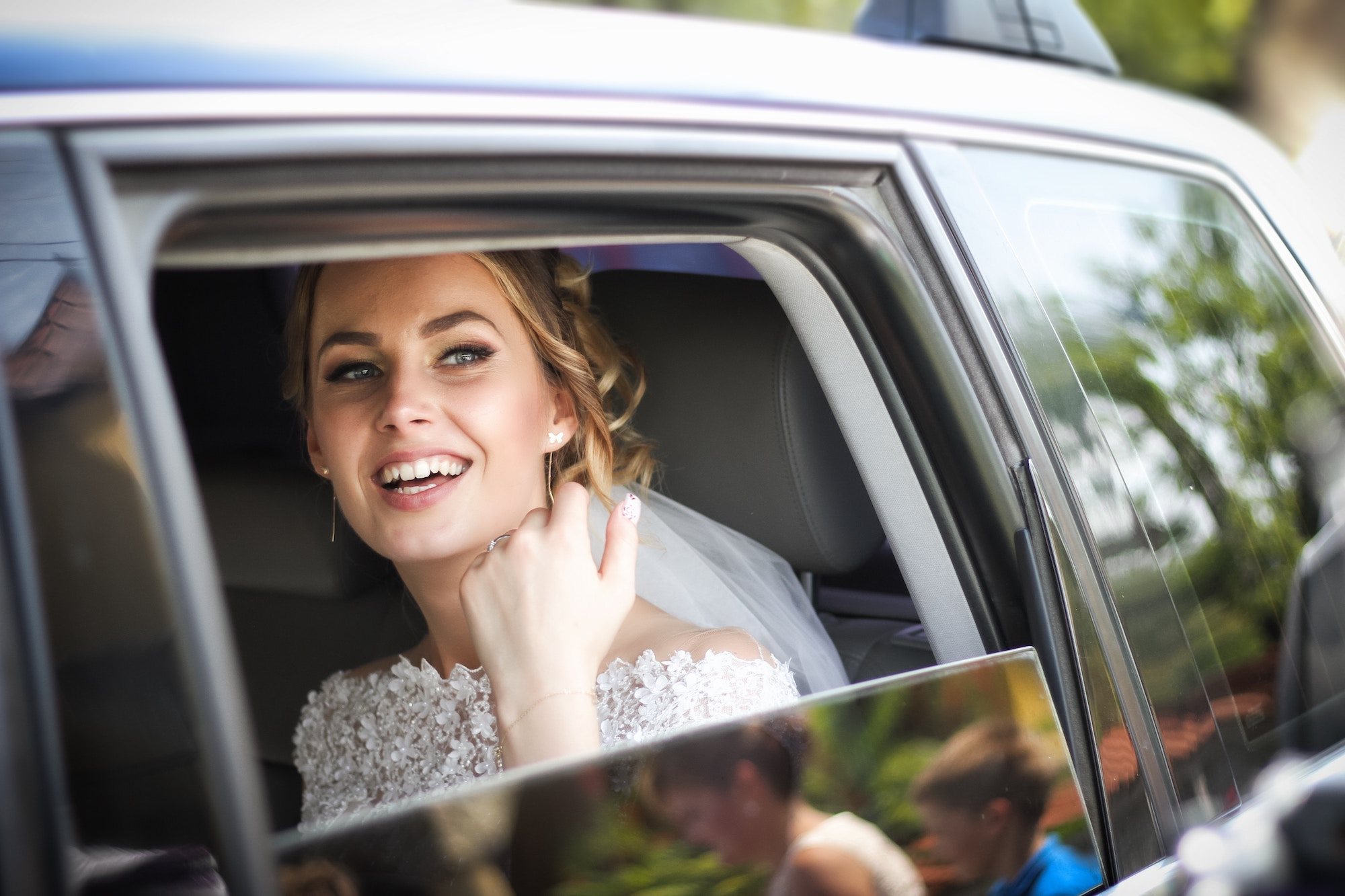Bride smiling from inside a limousine