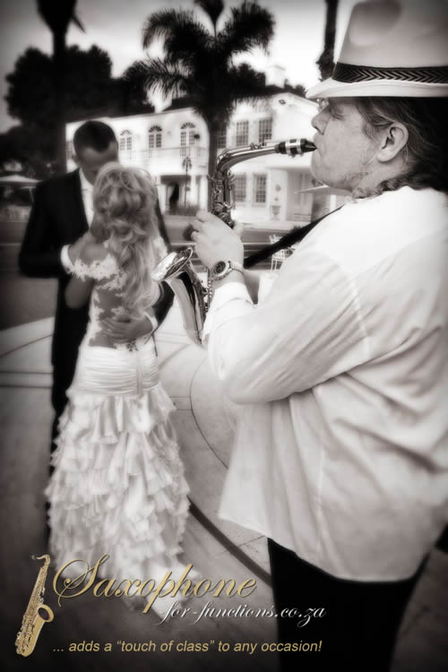 Saxophonist performing at a wedding with a couple dancing