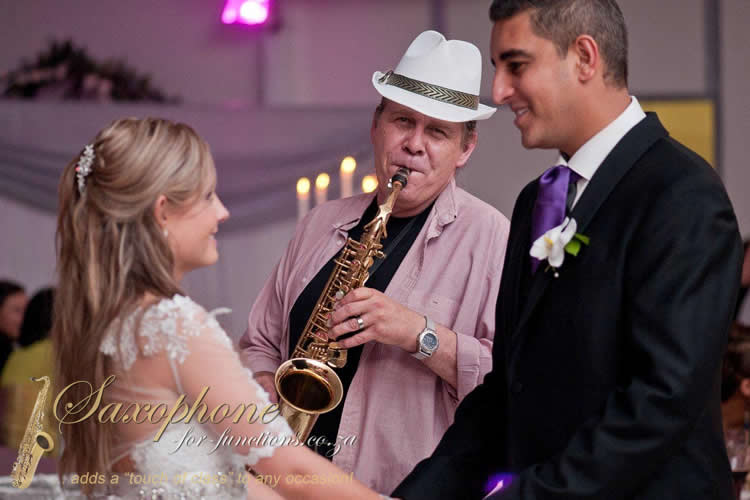 Saxophonist playing at a wedding with bride and groom