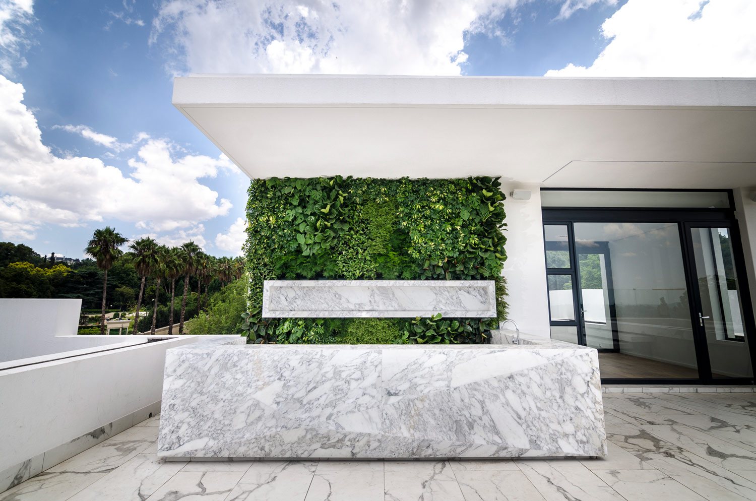 Rooftop vertical garden with lush greenery and marble counter.