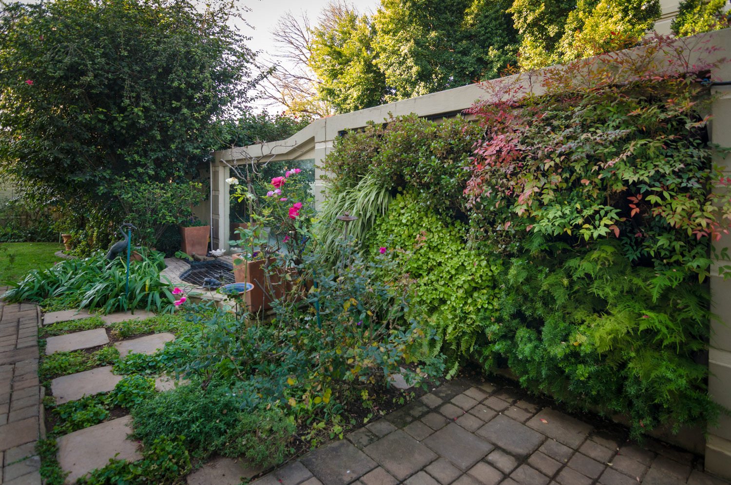 A vibrant vertical garden featuring various plants and flowers.