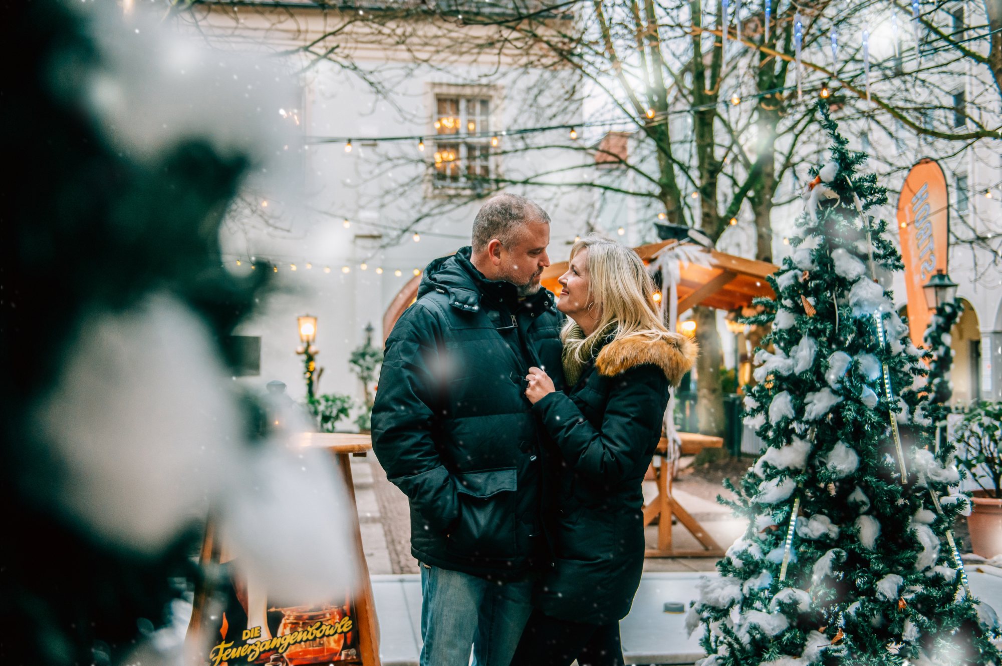 A couple enjoying a cozy moment in a decorated outdoor setting.