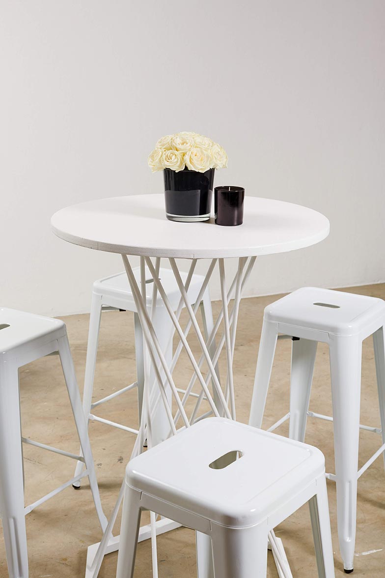 White cocktail table with stools and flower centerpiece