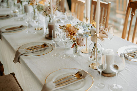 Elegantly set dining table with flowers and glassware.