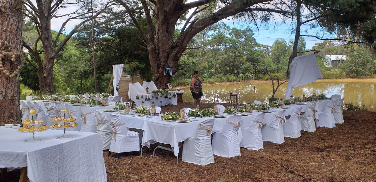 Table setup with white linens and floral decor by a dam