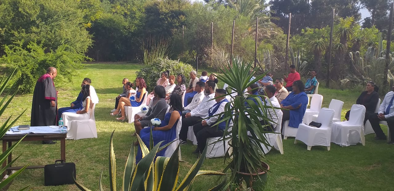 Outdoor ceremony with guests seated in a garden