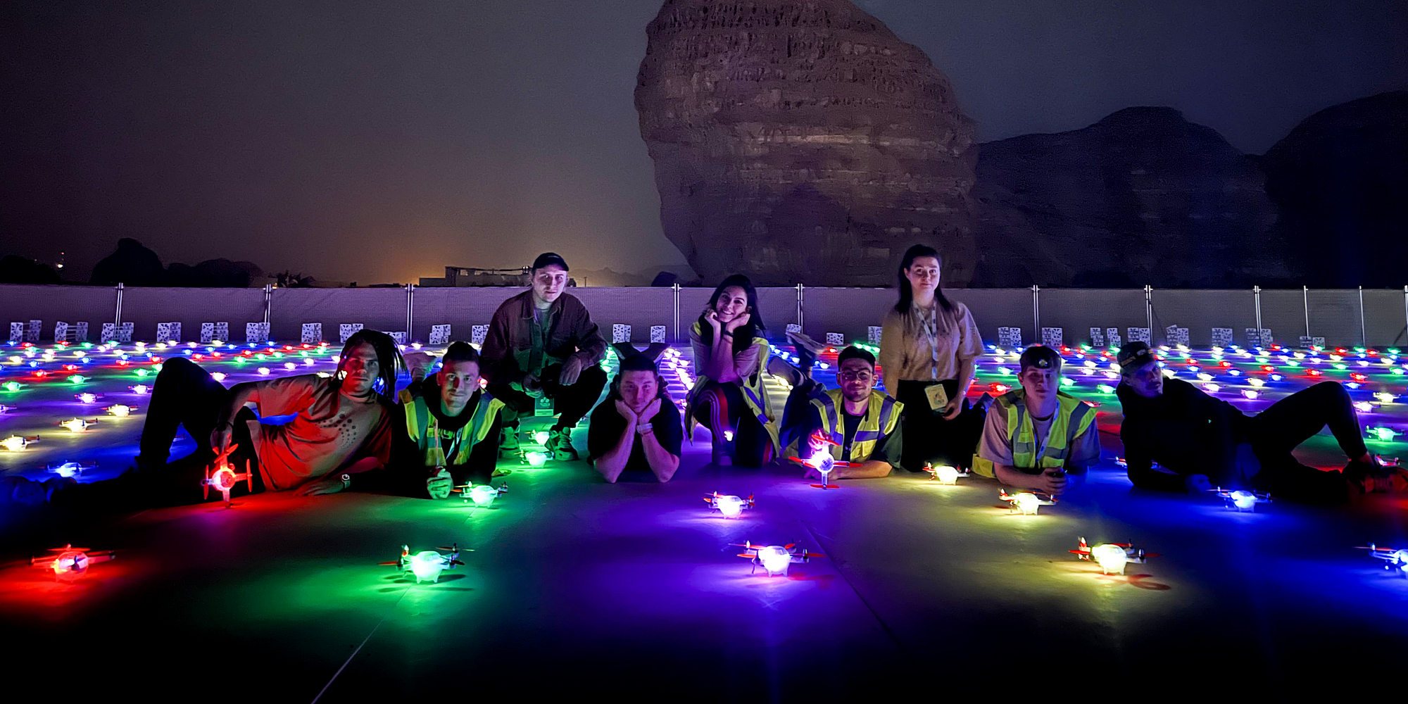 Team members on a rooftop with multicolored drones
