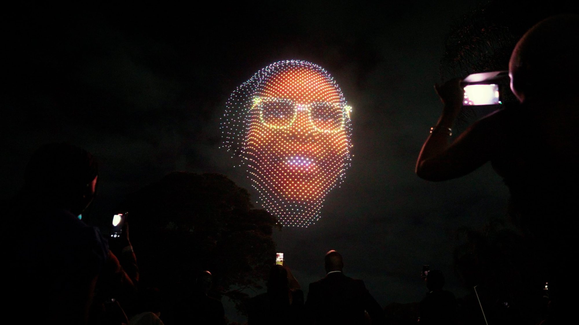 Aerial drone light display depicting a face against a night sky.