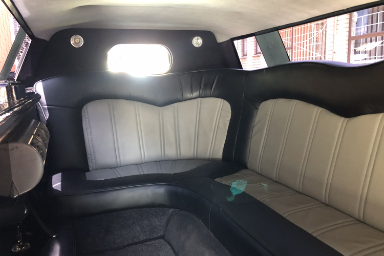 Interior view of a luxurious limousine with plush seating.
