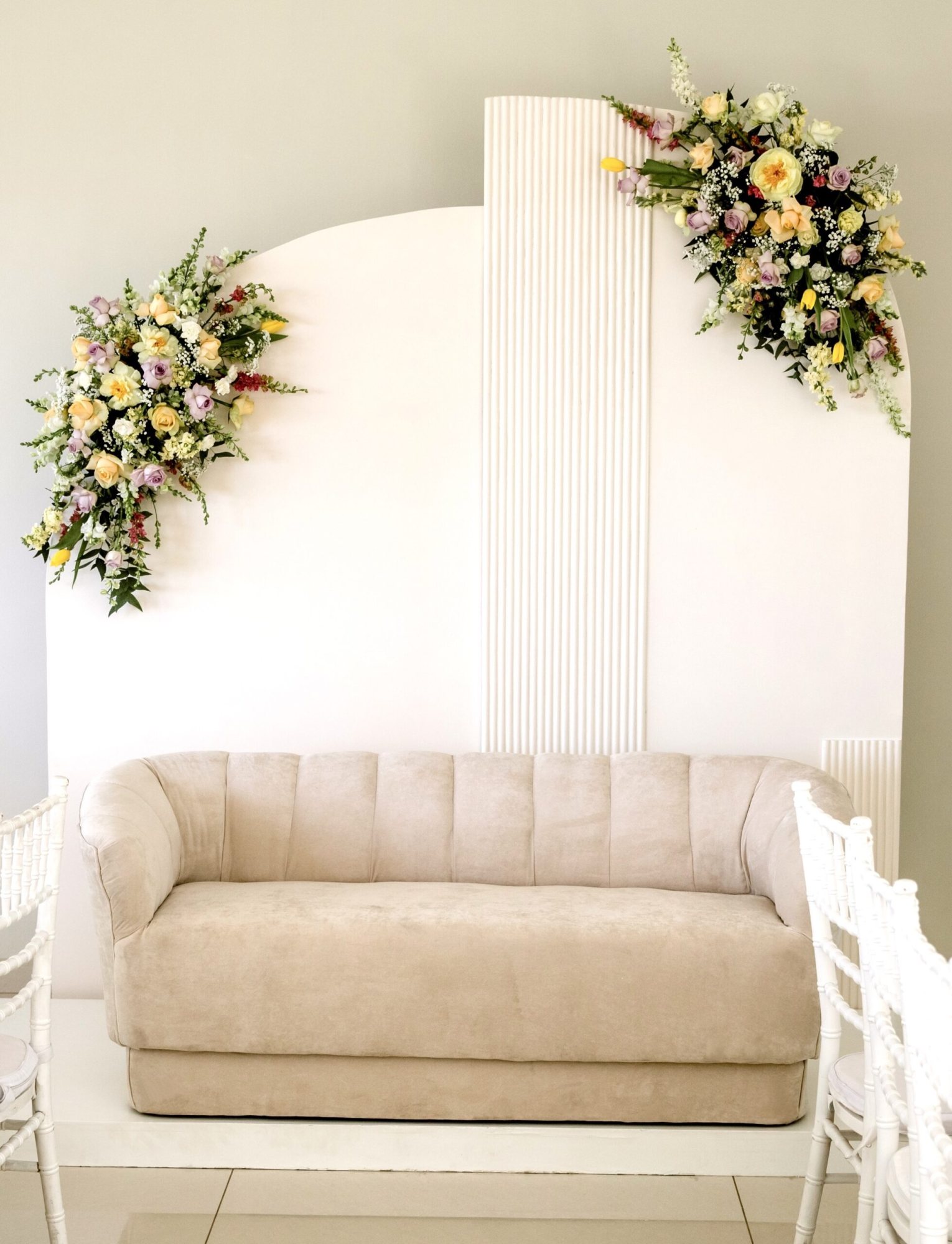 A chic lounge sofa with a floral backdrop.