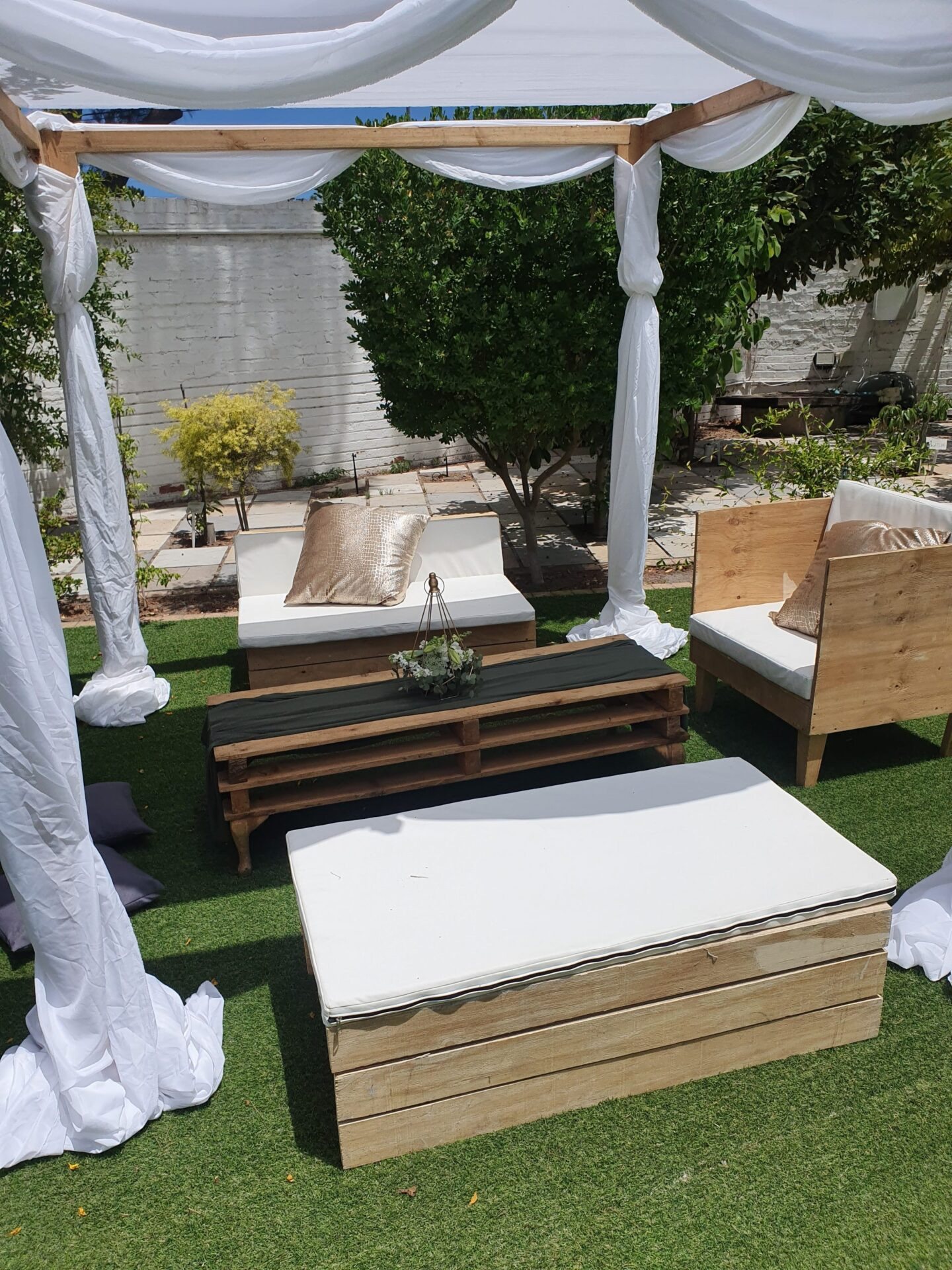 Outdoor lounge setup with seating and decor in a garden