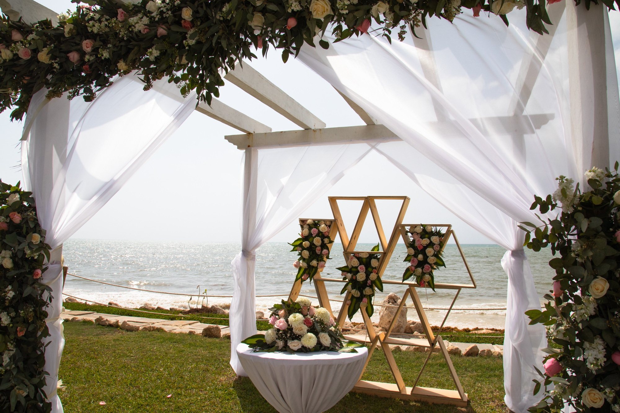 Wedding ceremony setup with floral arrangements by the sea